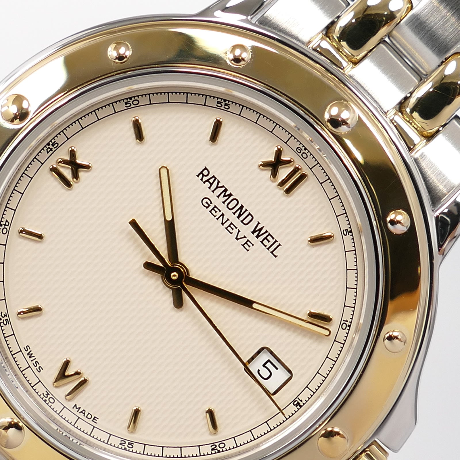 Raymond Weil Tango 5560 logo close up with quarter Roman Numerals
