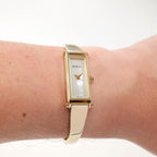 Gucci 1500L Ladies White Mother of Pearl Dial Gold Bangle watch on the wrist