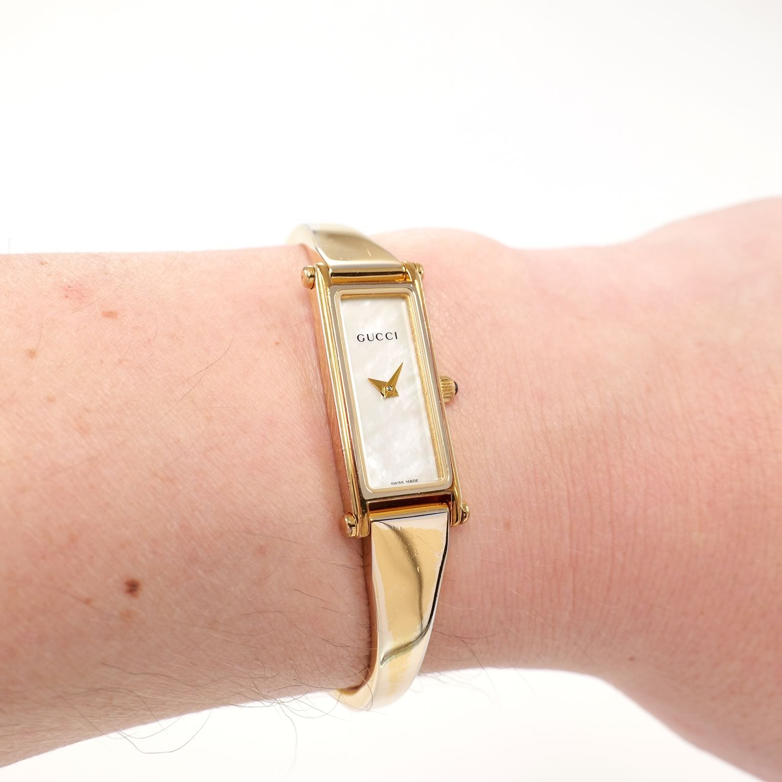 Gucci 1500L White Mother of Pearl 18k Gold Plated bangle watch on the wrist