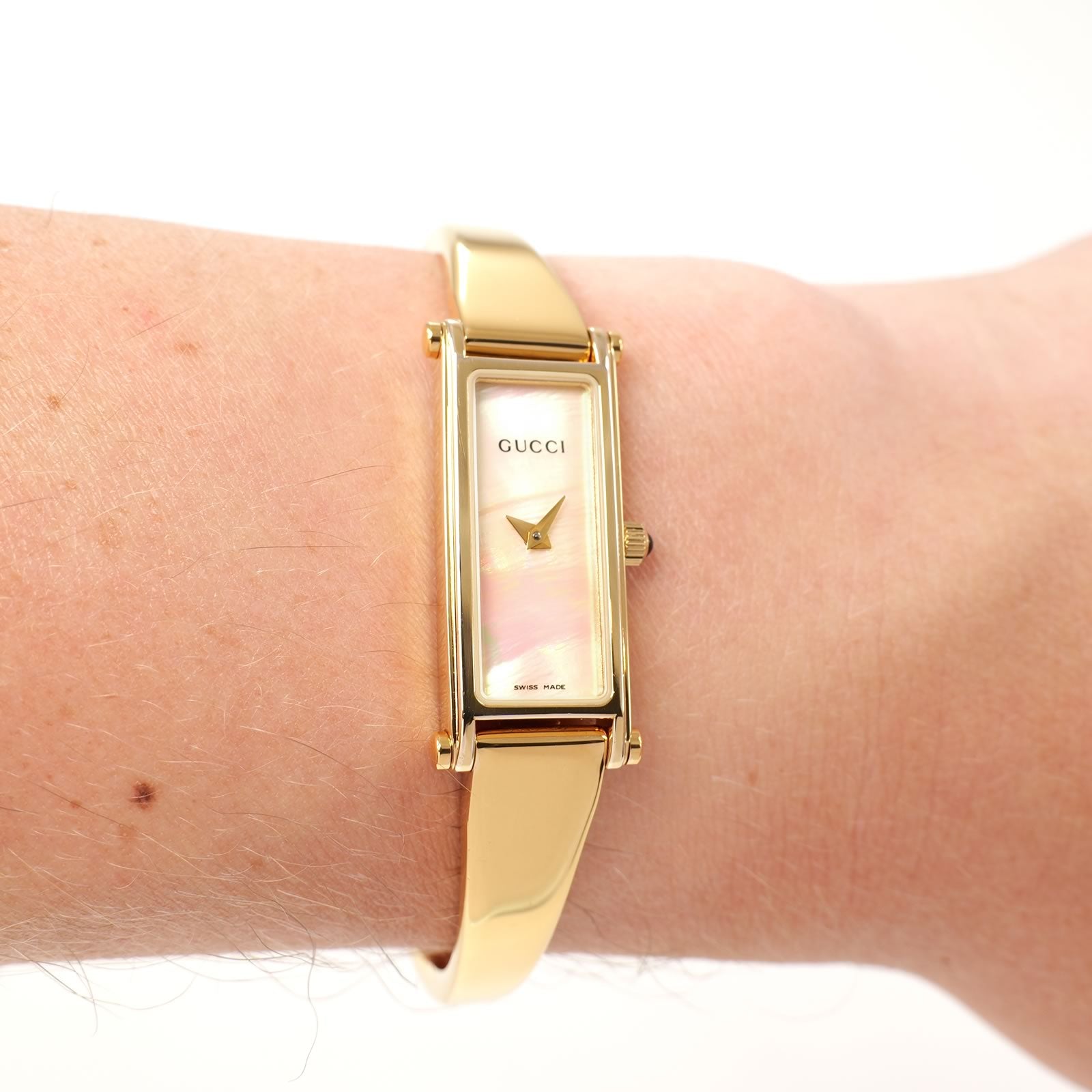 Gucci 1500L Ladies White Mother of Pearl Dial Gold Bangle watch on the wrist