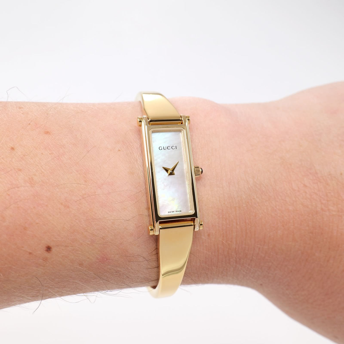 Gucci 1500L Ladies White Mother of Pearl 18k Gold Plated Bangle watch on the wrist