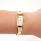 Gucci 1500L Ladies White Mother of Pearl Dial 18k Gold Plated Bangle watch on the wrist