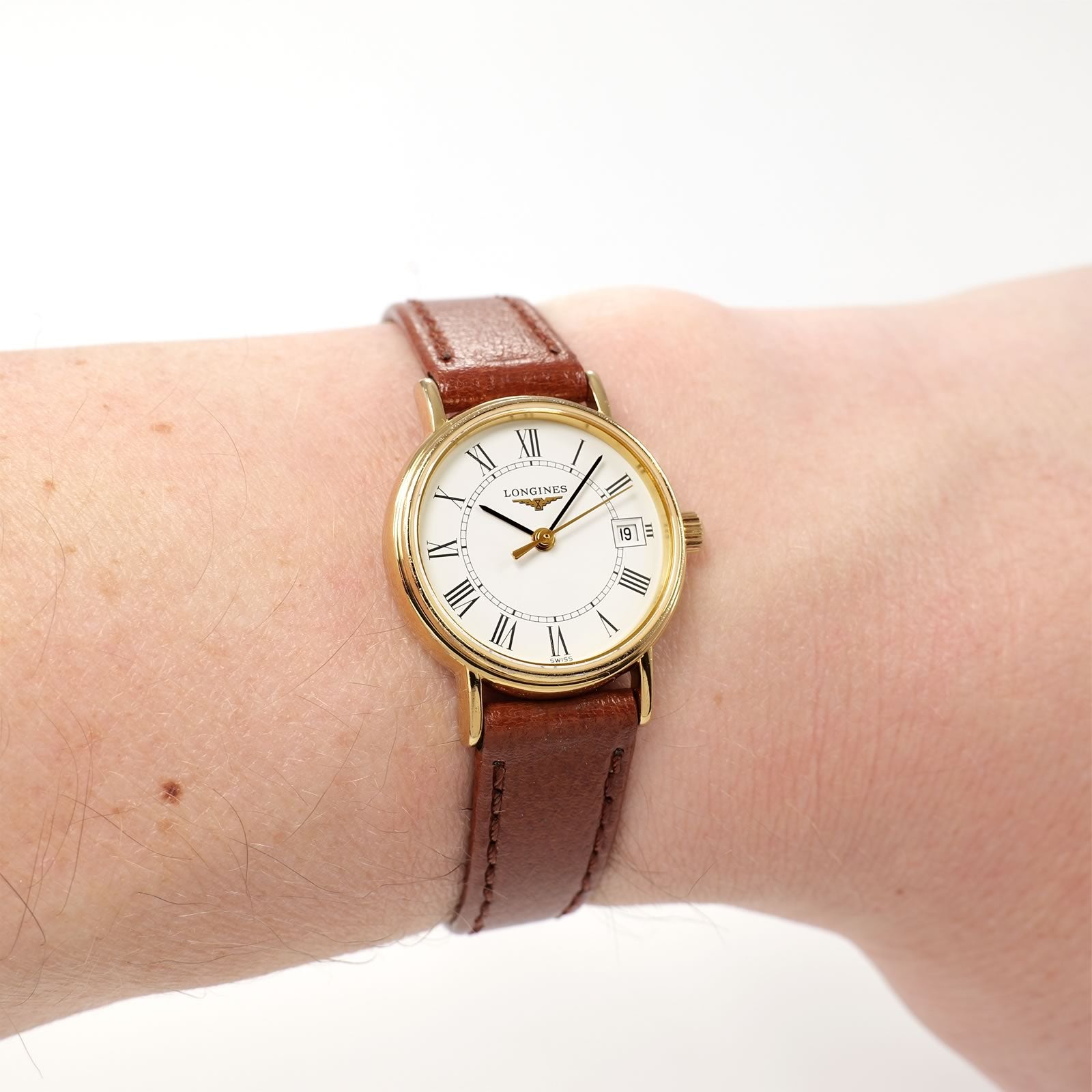 Longines Présence L4.220.2 White Roman Numeral Dial gold watch on the wrist